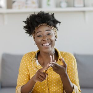 Pretty African American Woman Looking at Camera and Taking Part Video call Involved in Virtual Conferencing With Colleagues During Video Conference in the Office